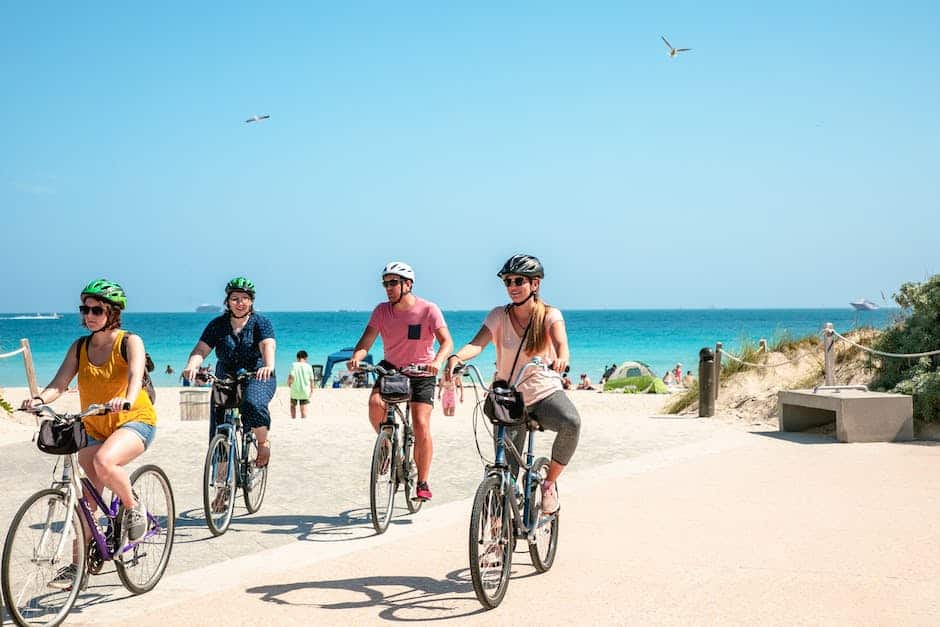 A group of people riding bicycles near a scenic beach.